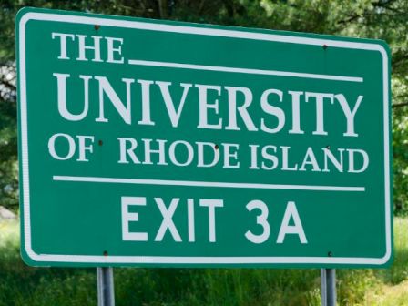 A green sign reads &ldquo;The University of Rhode Island&rdquo; and &ldquo;Exit 3A,&rdquo; with trees in the background.